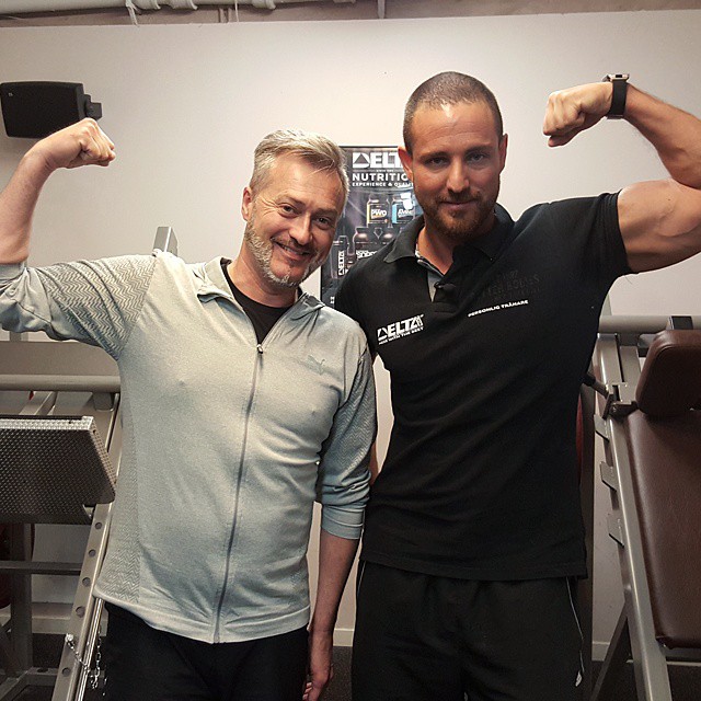 Philip Lailani och en kund spänner biceps tillsammans på gymmet
